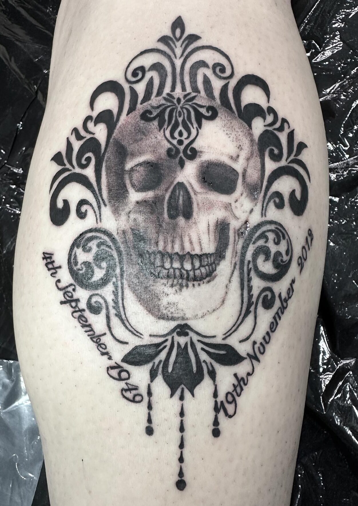 Skull and filigree tattoo on a leg calf by tattoo artist Marcus Kingsland at Markings Tattoos in Beverley, East Riding of Yorkshire.