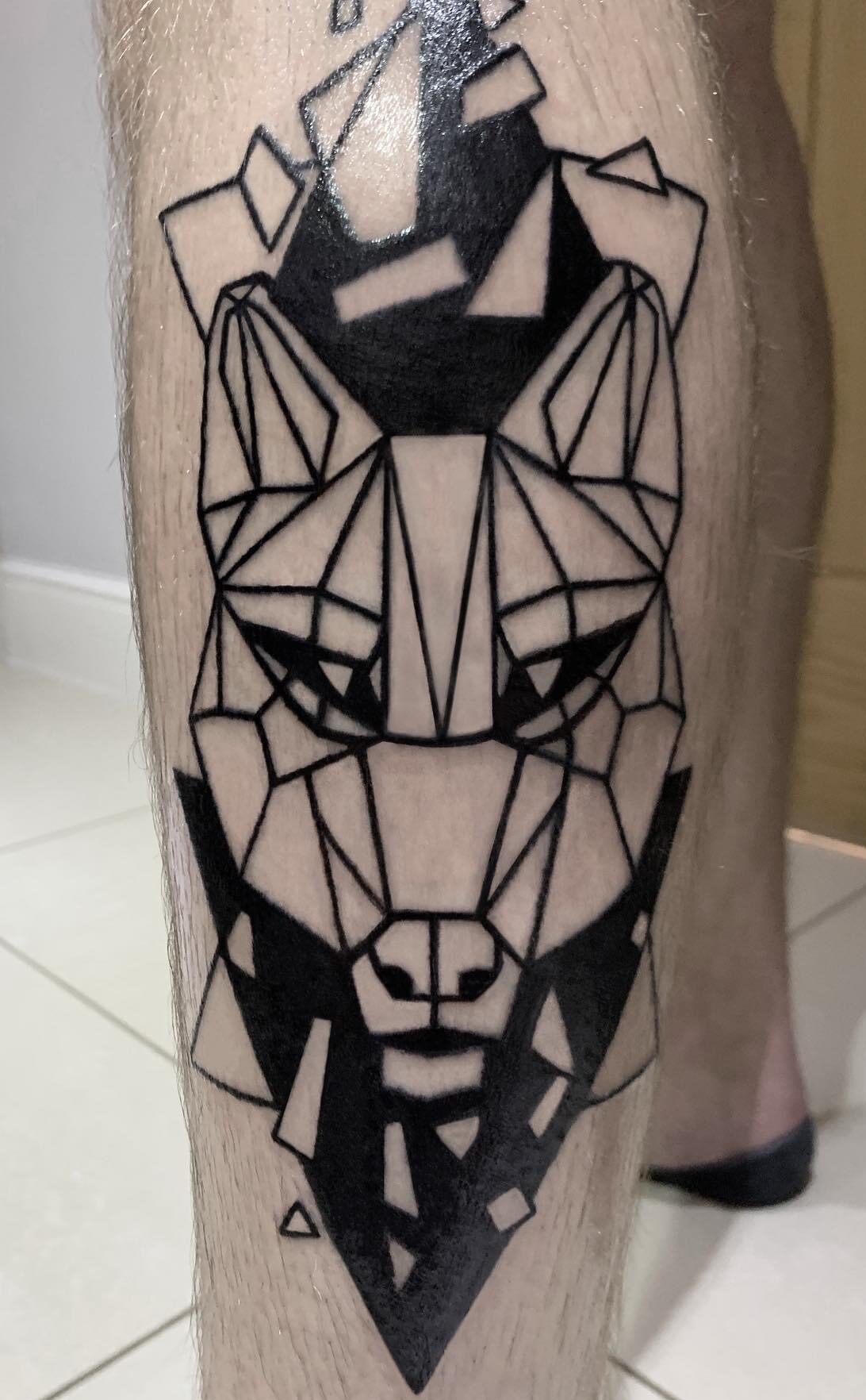 Geometric wolf tattoo on a leg calf by tattoo artist Marcus Kingsland at Markings Tattoos in Beverley, East Riding of Yorkshire.