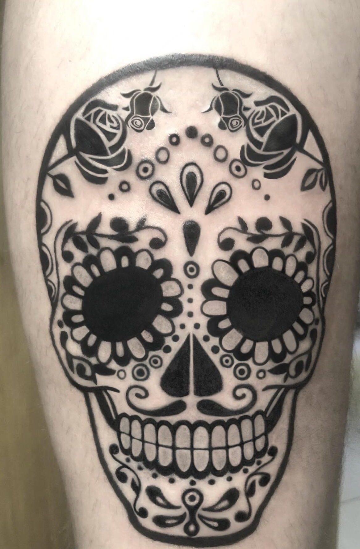 Mexican Day of the Dead skull tattoo on the thigh by tattoo artist Marcus Kingsland at Markings Tattoos in Beverley, East Riding of Yorkshire.